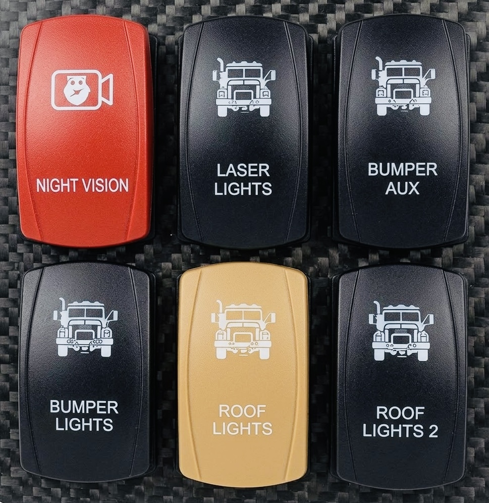 Six custom laser-engraved rocker switches in two rows: a red Night Vision switch with an owl camera icon, plus Laser Lights, Bumper Aux, Bumper Lights Roof Lights and Roof Lights 2 switches on carbon fiber